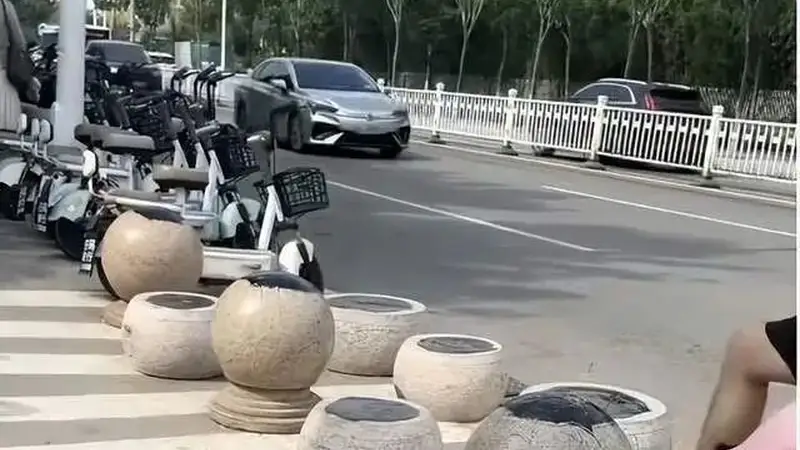 一海水浴场门口隔离石墩被涂抹沥青,游客带娃经过鞋和身上都粘上……